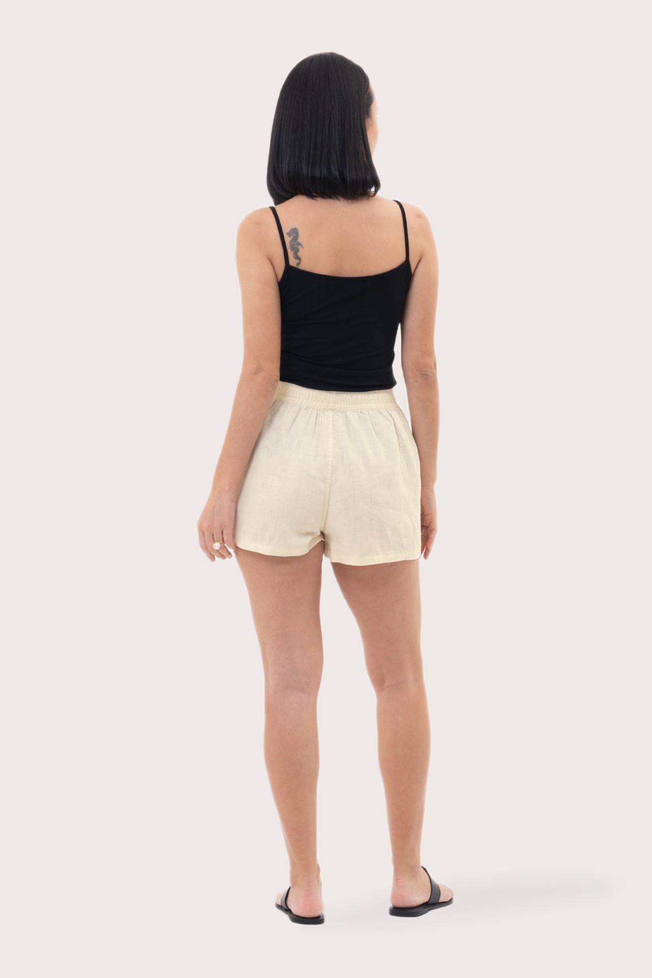 Back view of the Miwa Linen Short Creme highlighting the garment shape and drape