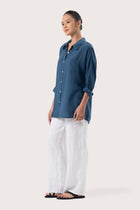 Side profile of the Muara Shirt Mustard showing its cut and natural movement.