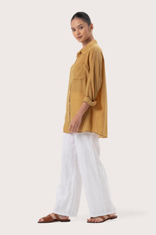 Side profile of the Muara Shirt Mustard showing its cut and natural movement.