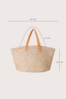 Profile view of the Natural Straw Tote Bag emphasizing its structured form and generous capacity