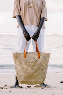 Natural Straw Tote Bag styled in a tropical resort setting with effortless coastal elegance