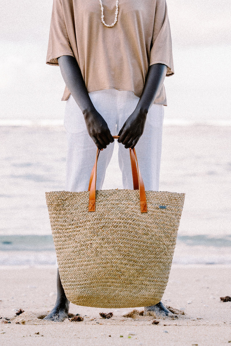 Natural Straw Tote Bag styled in a tropical resort setting with effortless coastal elegance