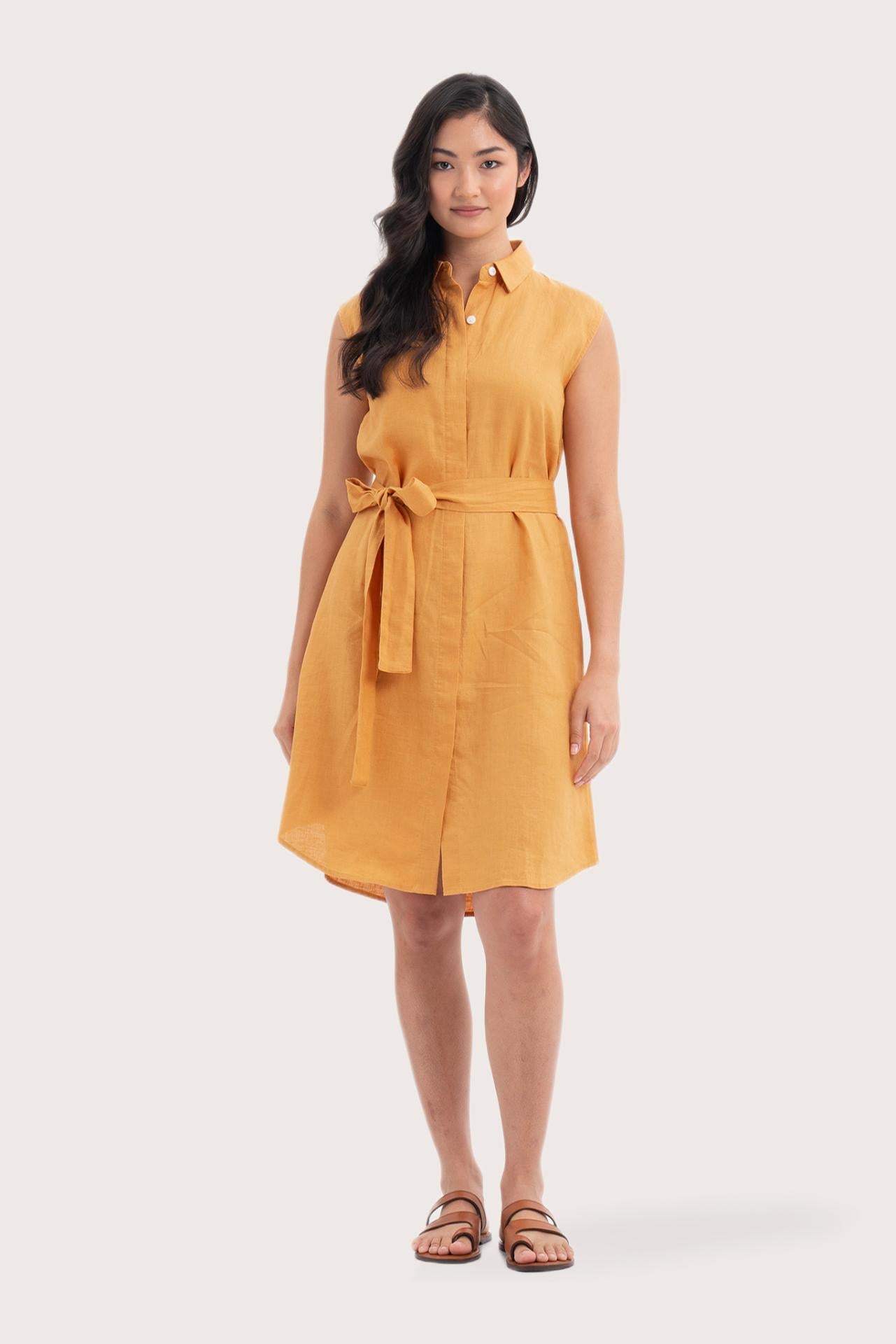 Woman wearing the Noelani Sleeveless Linen Dress Tangerine designed for effortless resortwear and tropical living by By The Sea Bali