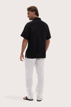 Back view of the black linen shirt with a relaxed and timeless silhouette