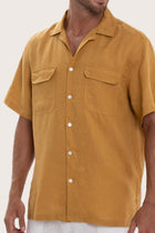 Close-up of the linen fabric texture and refined tailoring details on the yellow shirt