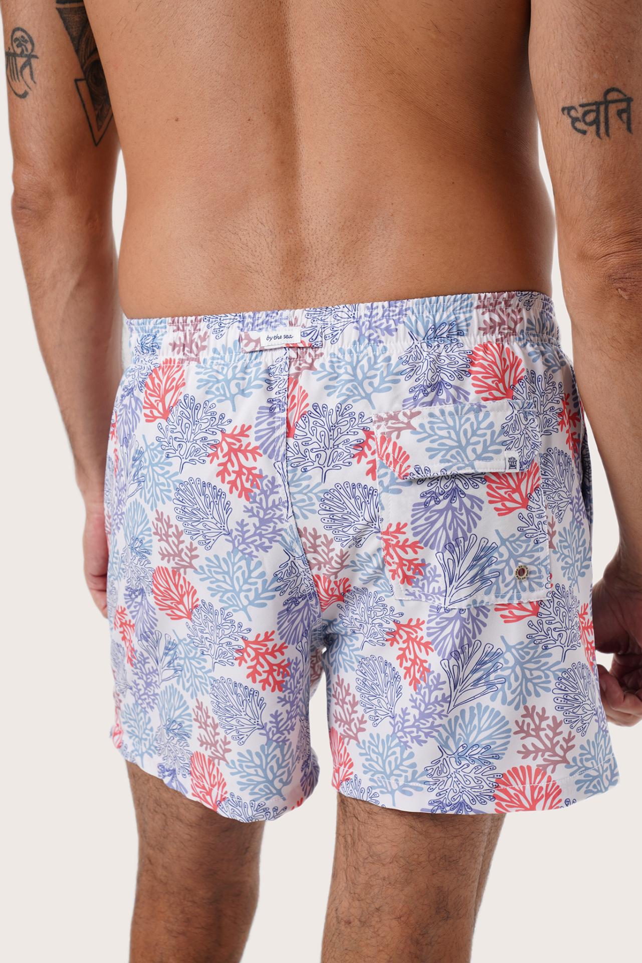 Men's beachwear styling featuring the Paco Swim Trunk in Pastel Coral Light Blue by By The Sea Bali