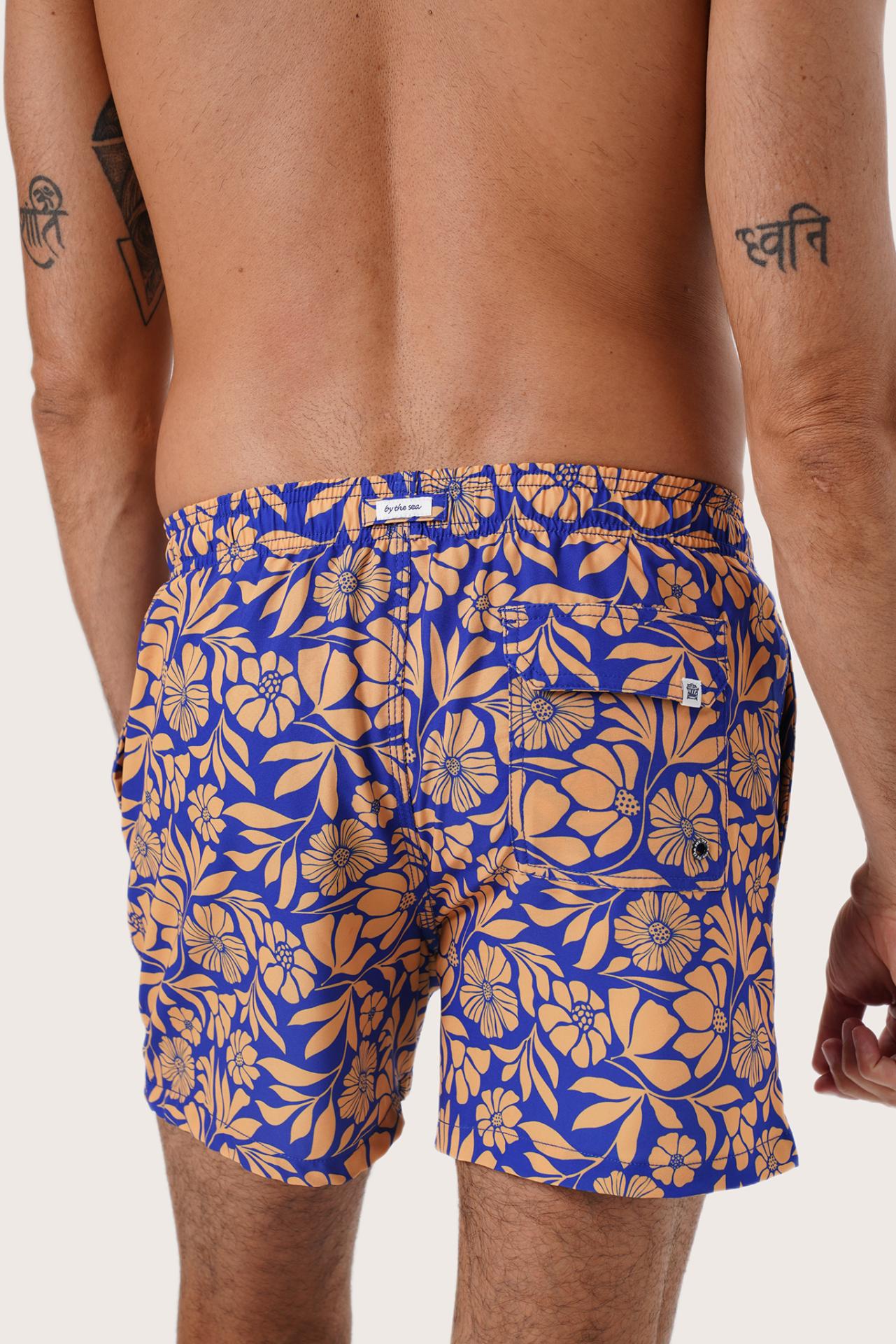 Men's beachwear styling featuring the Paco Swim Trunk in Spring Flora Orange by By The Sea Bali