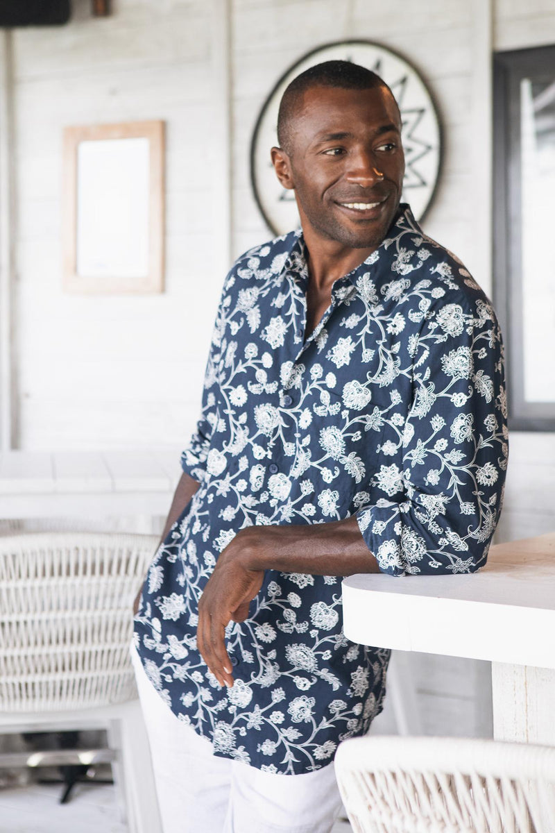 Model wearing the navy Garden Flower Panta cotton shirt in a tropical resort setting