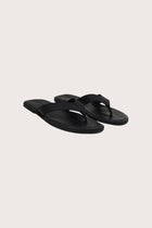 Paros leather sandals in nero front view showcasing elegant leather straps and minimalist resort aesthetic
