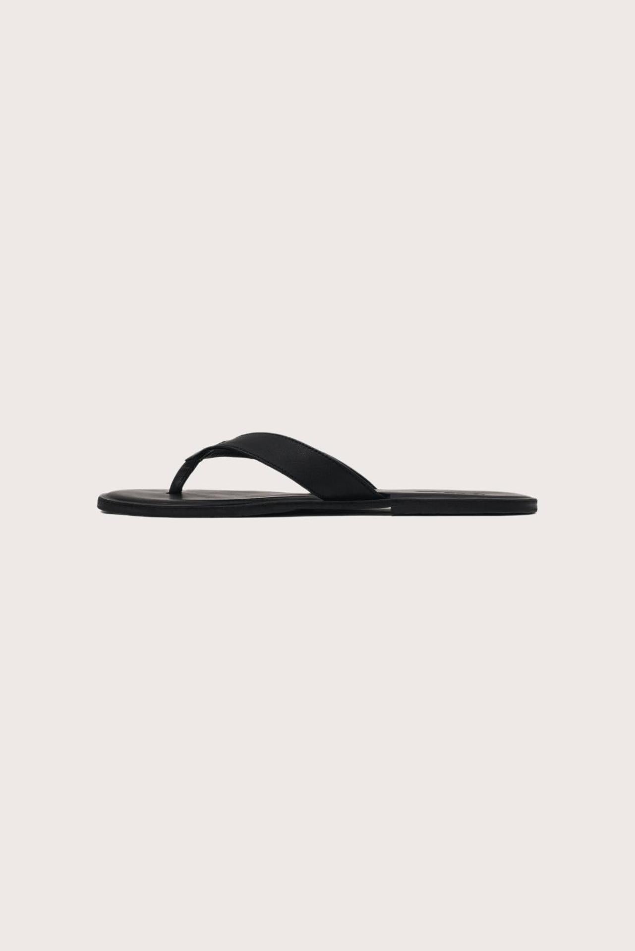 Side profile of Paros leather sandals in nero highlighting sleek and modern resort footwear silhouette