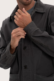 Close-up of the cotton fabric texture and refined jacket detailing in dark brown
