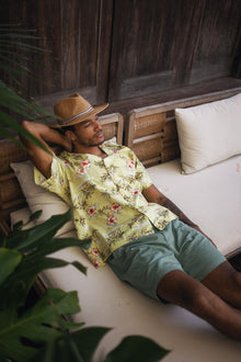 Model wearing the sage Paulo Bermuda shorts in a tropical resort setting
