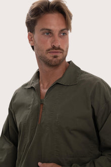 Woman wearing the dark brown cotton Pescador outerwear in a tropical resort setting