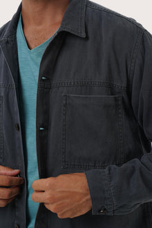 Close-up of the cotton fabric texture and refined detailing on the navy jacket