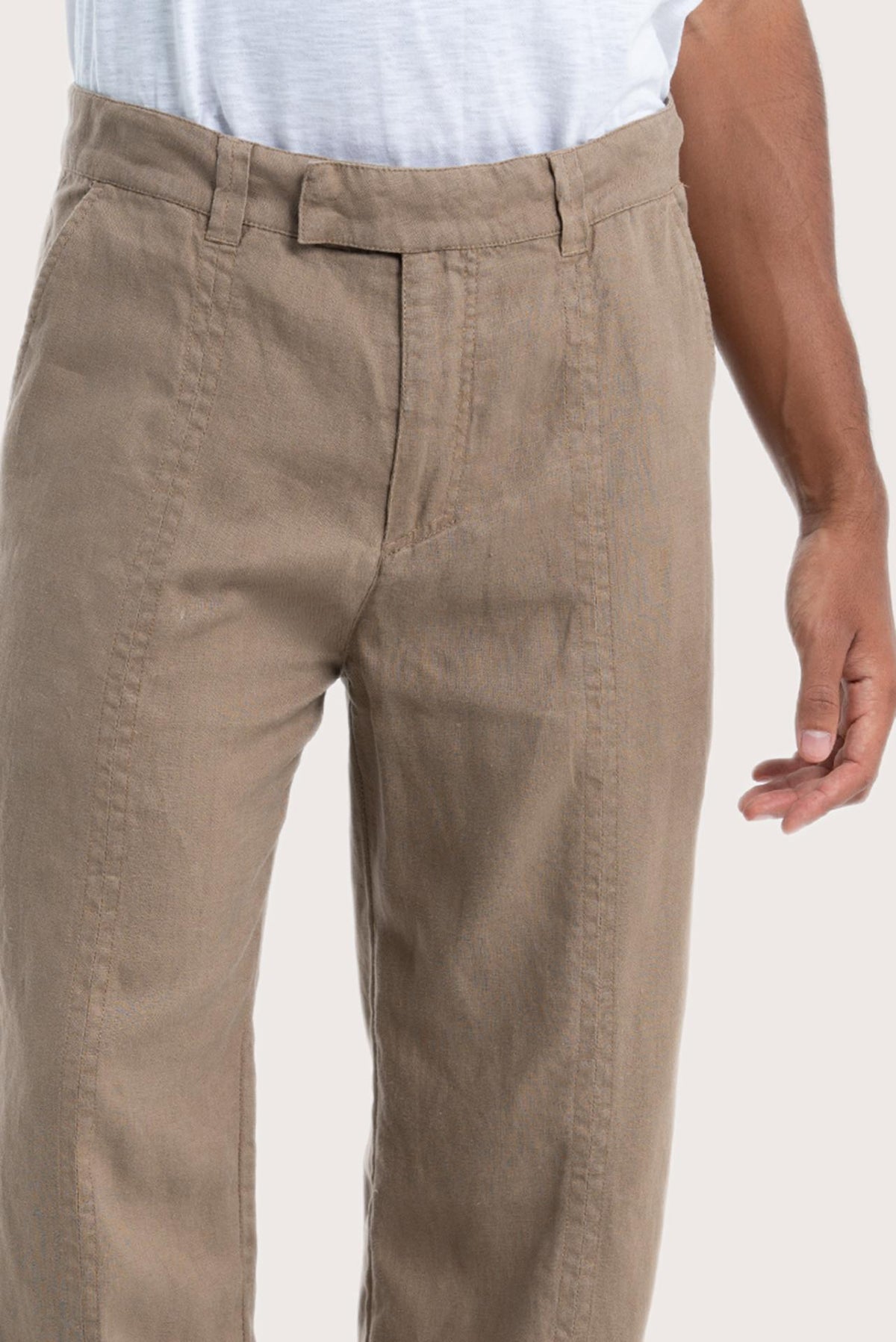 Close-up of the linen fabric texture and tailored detailing on the cream pants