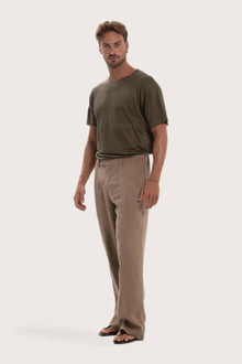 Side profile of the cream linen Rosca pants showcasing their effortless drape