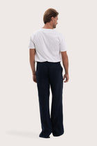 Back view of the navy linen pants with a relaxed and elegant silhouette