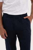Close-up of the linen fabric texture and tailored detailing on the navy pants
