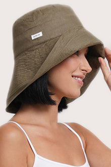 Luxury resort styling featuring the Savanna Linen Hat Brown in a tropical coastal setting