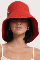 Luxury resort styling featuring the Savanna Linen Hat Red in a tropical coastal setting