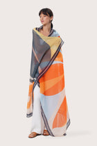 By The Sea Bali Savaya Sarong in Sunset Breeze Orange featuring a vibrant tropical print, worn as an elegant wrap silhouette