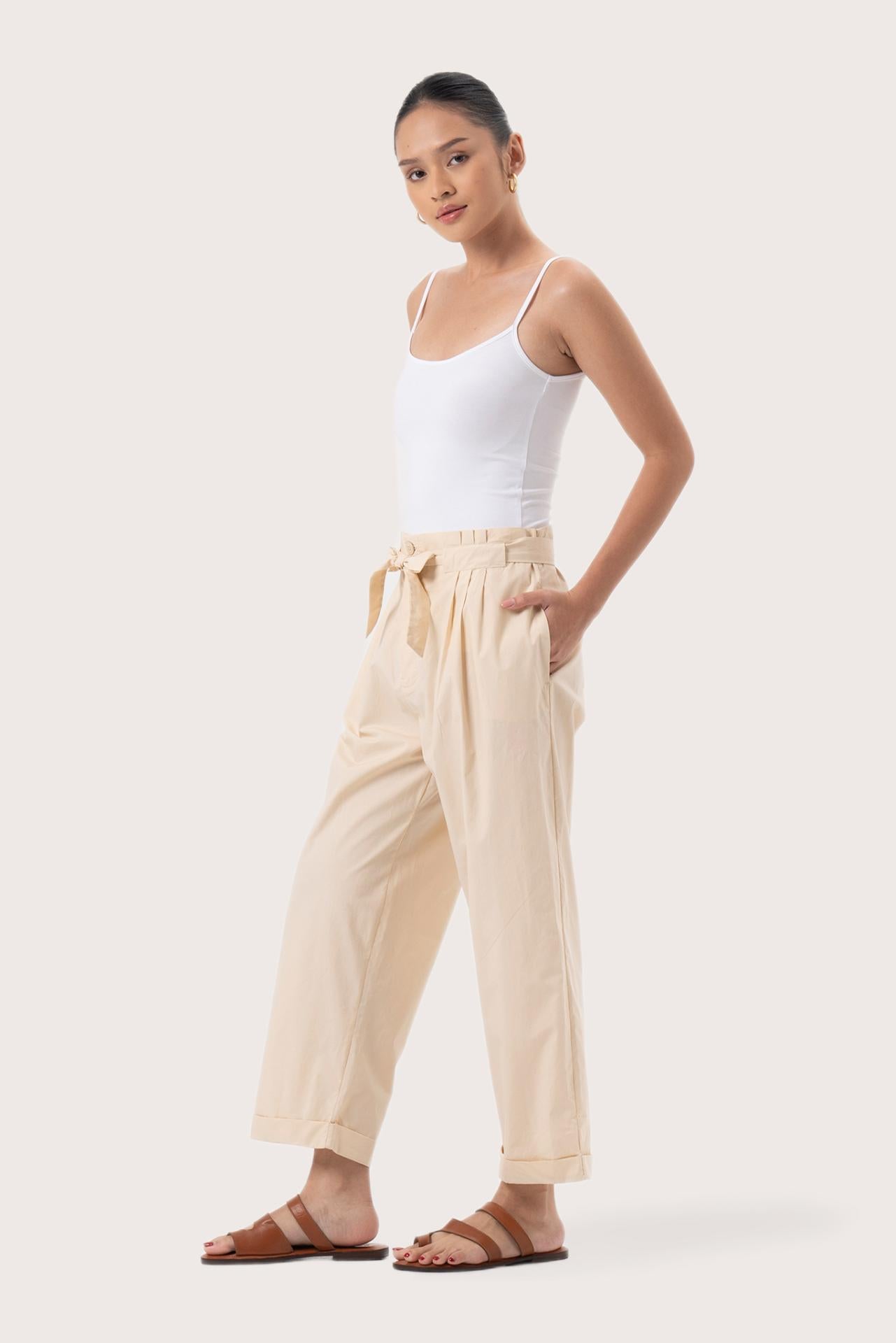 Side profile of the Sawangan Cotton Pants Cream showing its cut and natural movement.