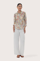 Woman wearing the Selva Shirt Crisante Multicolor Light Blue Base designed for effortless resortwear and tropical living by By The Sea Bali.