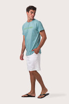 Side profile of the Skala Surf Canggu t-shirt Turquoise by By The Sea Bali – relaxed drape and understated island elegance
