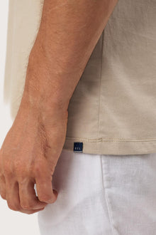 Angled detail of the Skala T-Shirt Beige by By The Sea Bali – refined craftsmanship up close