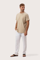 Side profile of the Skala T-Shirt Beige by By The Sea Bali – relaxed drape and understated island elegance
