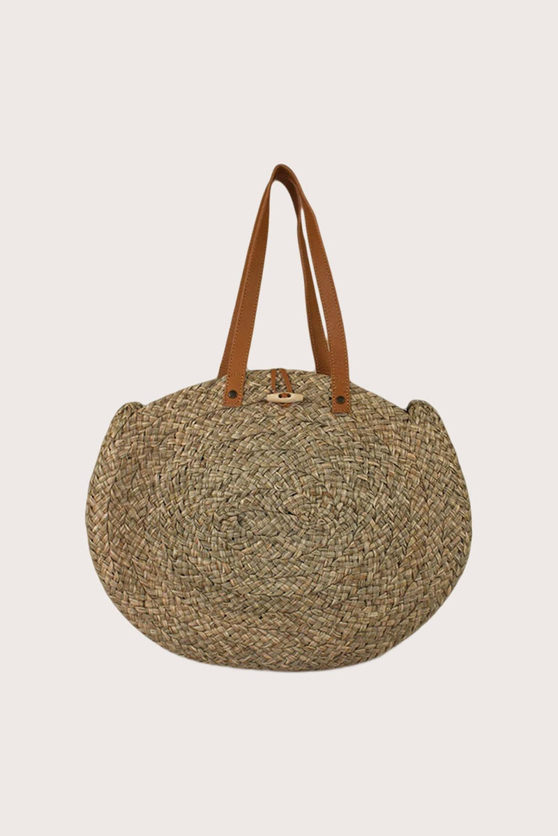Back view of handcrafted straw round bag with circular silhouette and natural weave texture