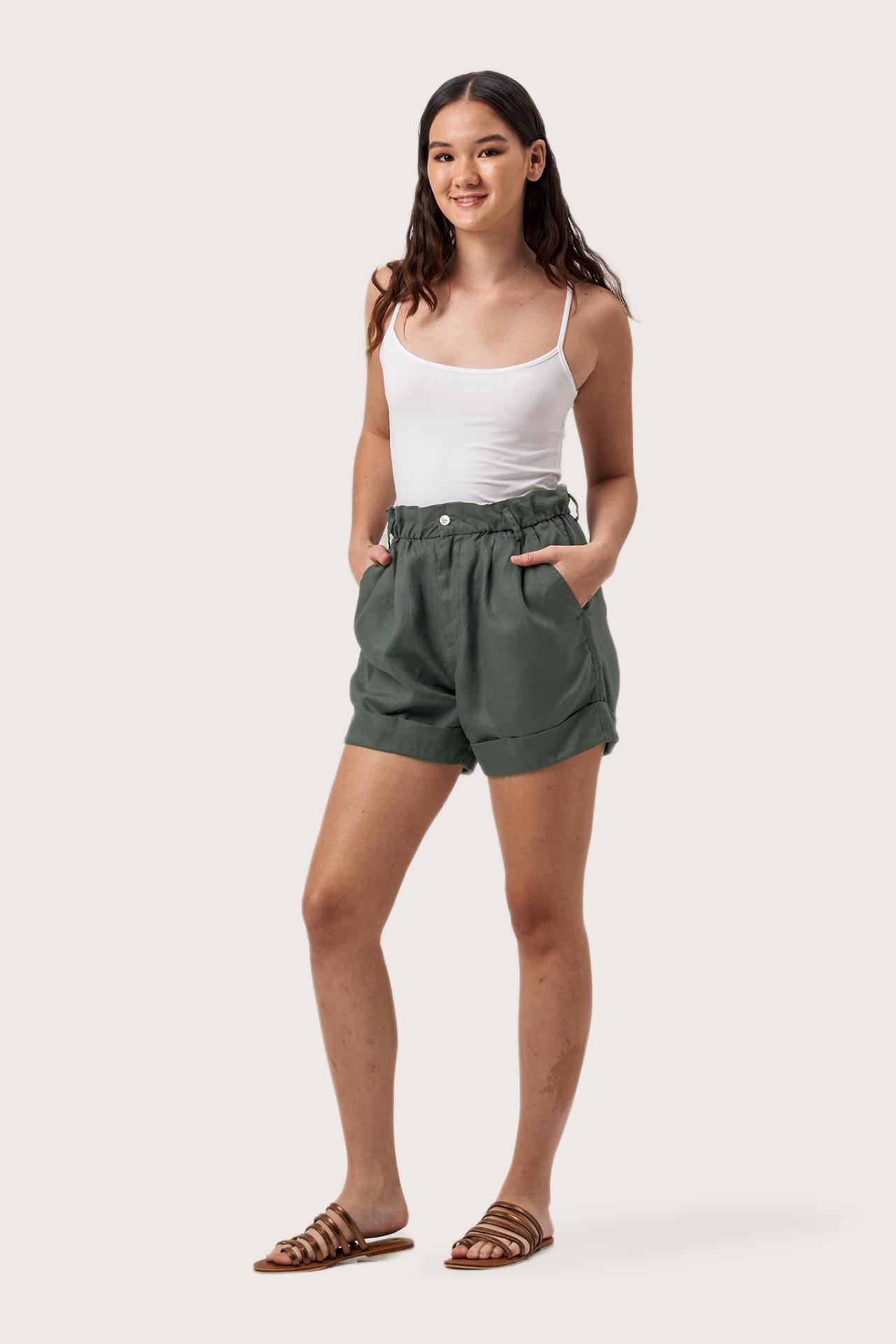 Side profile of the Taloo Linen Bermuda Foglie Dark Green showing its cut and natural movement