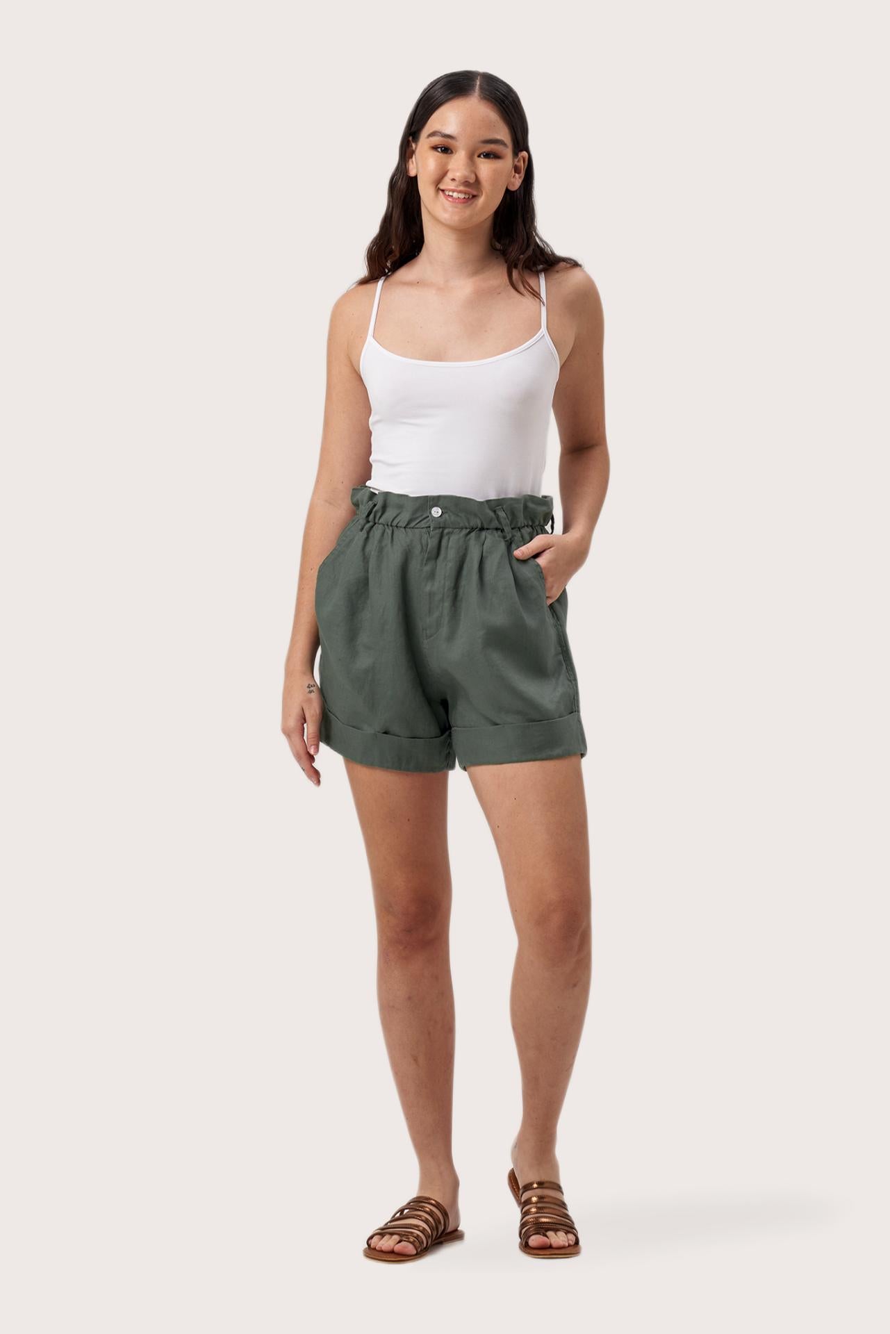 Woman wearing the Taloo Linen Bermuda Foglie Dark Green designed for effortless resortwear and tropical living by By The Sea Bali