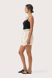 Side profile of the Taloo Linen Bermuda Crema showing its cut and natural movement
