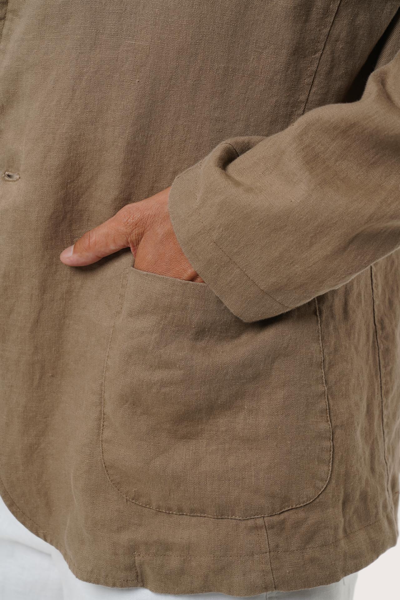 Close-up of the linen fabric texture and tailored details on the brown blazer