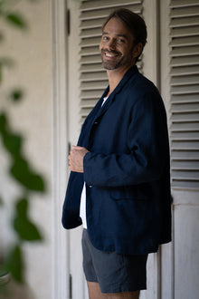 Man wearing the La Brisa linen Tenggara jacket in a tropical resort setting