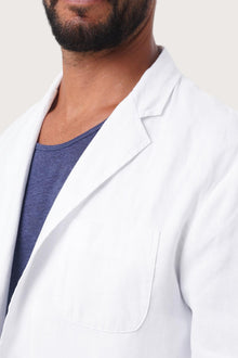 Close-up of the linen fabric texture and refined tailoring details on the white jacket
