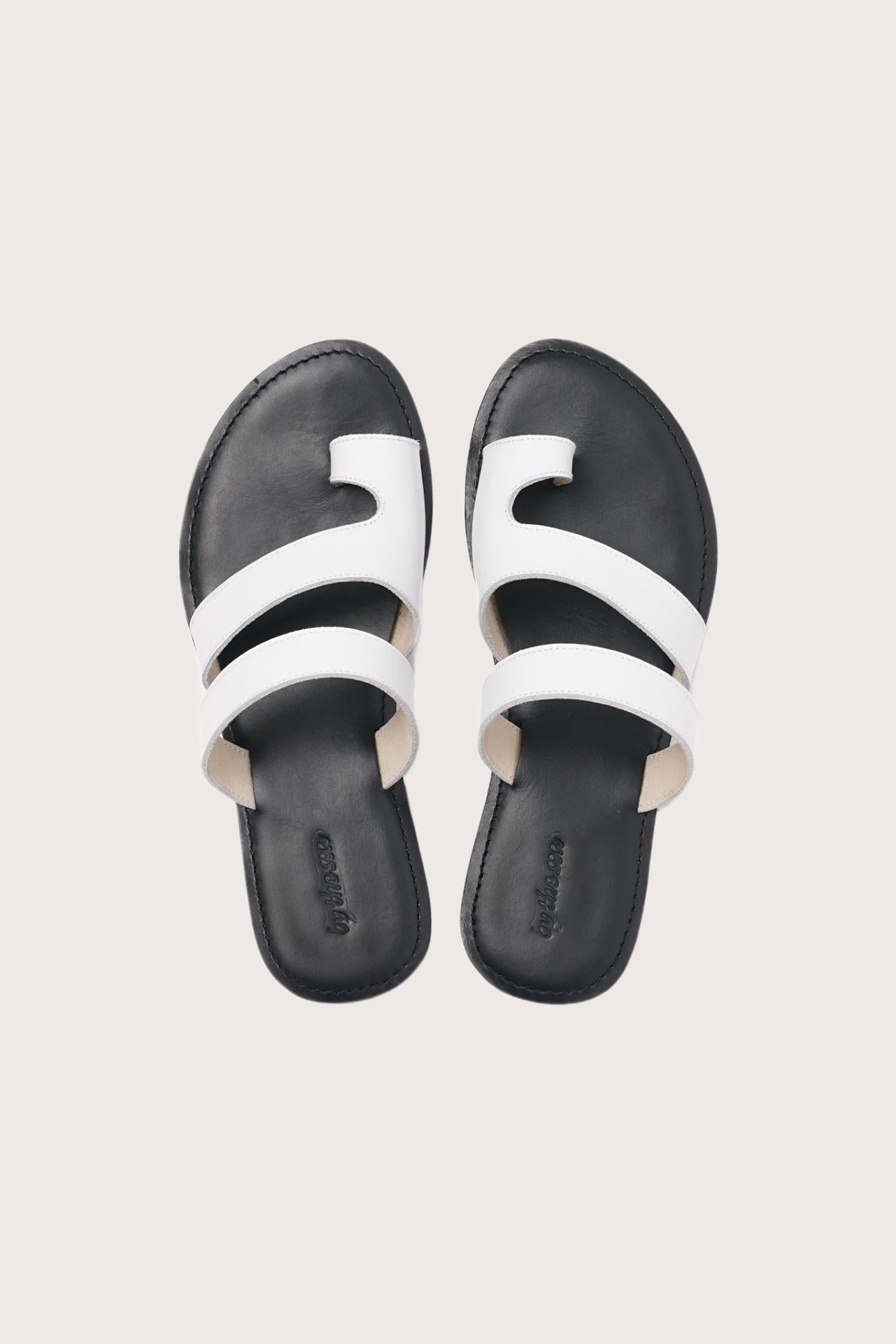 Terra sandal in white and black shown in a global view highlighting its full silhouette and refined resort design