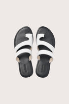 Terra sandal in white and black shown in a global view highlighting its full silhouette and refined resort design