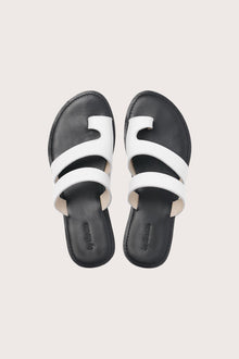 Terra sandal in white and black shown in a global view highlighting its full silhouette and refined resort design