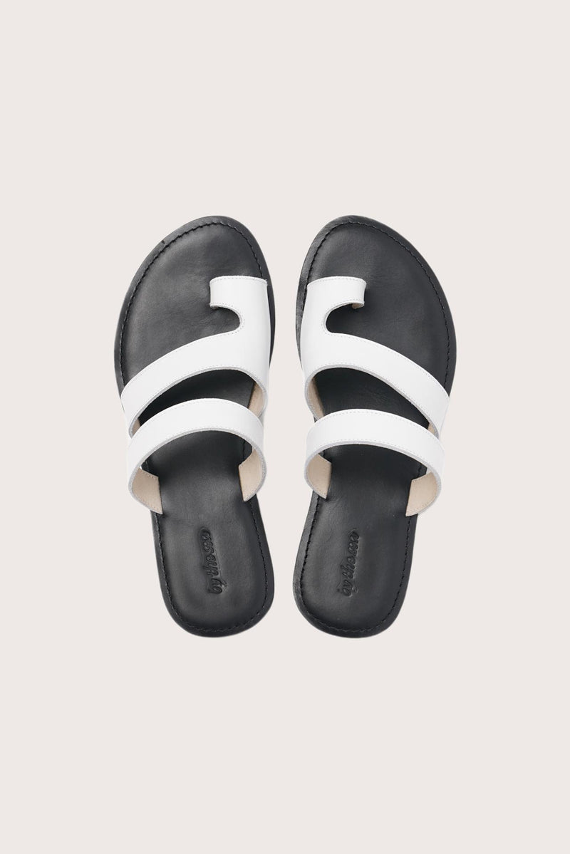 Terra sandal in white and black shown in a global view highlighting its full silhouette and refined resort design