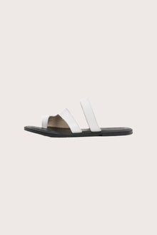 Side profile of Terra sandal in white and black highlighting sleek and modern resort footwear silhouette