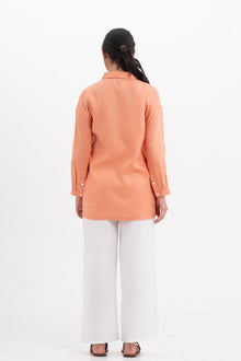 Back view of the Tifa Linen Shirt Orange highlighting the garment shape and drape.