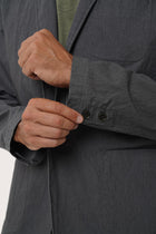 Close-up of the cotton polyester spandex fabric texture and tailored detailing on the dark grey blazer