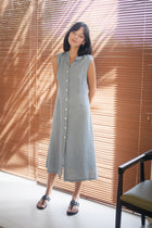 Woman wearing a linen sleeveless Veria Dress standing in the resort by By The Sea Bali