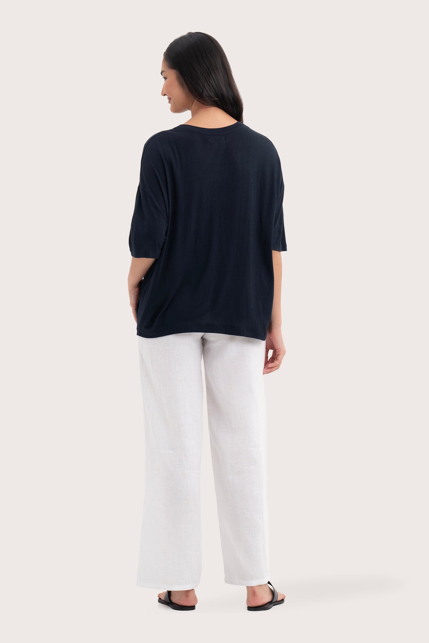 Back view of the Yara Top Navy highlighting the garment shape and drape.