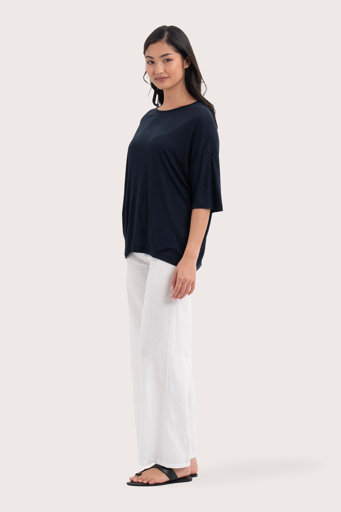 Side profile of the Yara Top Navy showing its cut and natural movement.