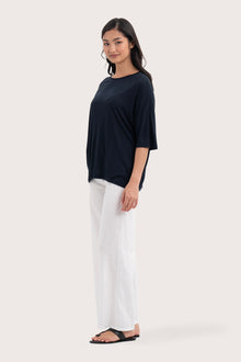 Side profile of the Yara Top Navy showing its cut and natural movement.