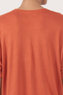 Back view details of the Yara Top Orange highlighting the garment shape and drape.