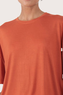 Close up front of the Yara Top Orange highlighting craftsmanship and design features.